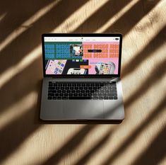 an open laptop computer sitting on top of a wooden table