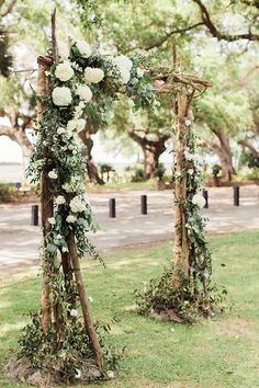 the wedding arch is decorated with white flowers and greenery for an outdoor ceremony at southern chic lowndes