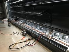 the inside of a large industrial oven with wires and other equipment on the floor next to it