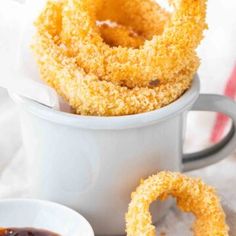 fried onion rings in a mug with dipping sauce