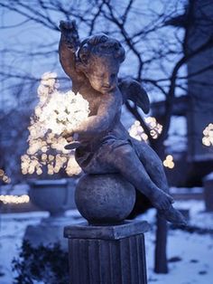 a statue sitting on top of a pole in the snow