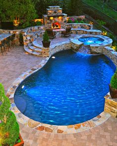 an outdoor swimming pool surrounded by patio furniture and fire pit with seating areas around it