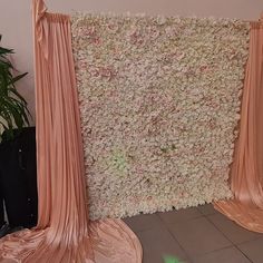 the backdrop is made up of pink silk and draping with flowers on it