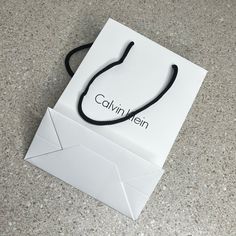 a white paper bag with a black string attached to it that says cavin mein