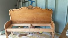 a wooden bench sitting on top of a hard wood floor next to a blue wall