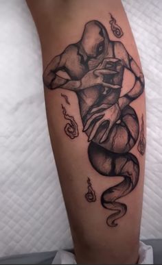 a black and white tattoo on the leg of a person with an octopus in it