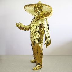 a golden statue with a sombrero on it's head and hands in the air