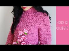 a woman wearing a pink crochet sweater with flowers on the collar and sleeves