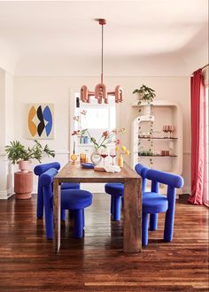 a dining room with blue chairs and a wooden table