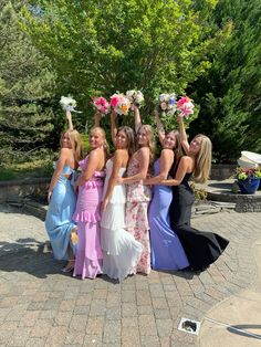 a group of women standing next to each other holding bouquets in front of them