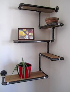 the shelves are made out of pipe pipes and have pots on them, with a small potted plant next to it