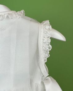 A delicate dress and bonnet made in white organza with pleats and laces. The dress has two ribbon bows on the sides, and buttons on the back for closure. Made in Spain Dry clean Final sale, no exchanges nor returns are available Lace First Communion Dress With Ruffles For Party, Fitted Sleeveless Ruffled First Communion Dress, Fitted Ruffle Dress For First Communion, Elegant Fitted Baptism Dress With Ruffles, Classic White Dress With Lace Bodice, Classic White Dresses With Lace Sleeves, Formal Lace Dress With Bow, Lace Victorian Dress With Ruffles For Formal Occasions, Formal Lace Victorian Dress With Ruffles