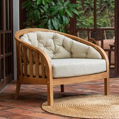 a wooden chair sitting on top of a brick floor next to a potted plant