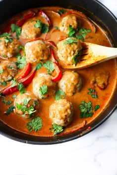 a skillet filled with meatballs, peppers and sauce on top of a white counter