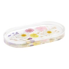 a plastic container filled with flowers on top of a white surface