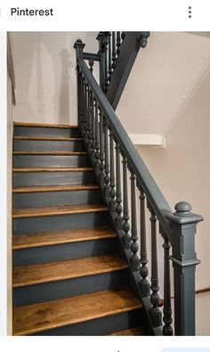 the stairs are painted blue and have wooden balustiers on them, along with black railings