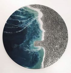 a circular artwork with an image of a woman's face in the water