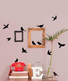 the birds are flying in the air above the table and on the wall next to the phone