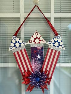 an american flag wreath hanging from a window with the stars and stripes painted on it