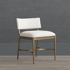 a white chair sitting on top of a hard wood floor next to a gray wall