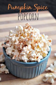 a blue bowl filled with popcorn on top of a wooden table