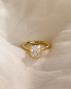 a diamond ring sitting on top of a white cloth