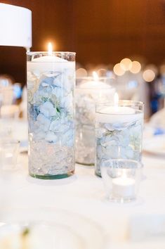 candles and flowers in glass vases on a table