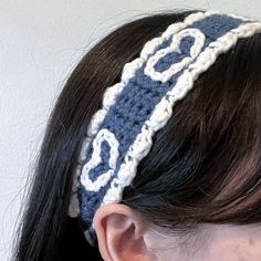 a woman wearing a crocheted headband with the word love written on it