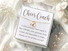 a card with the words cheer coach on it next to some flowers and white carnations