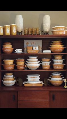 a wooden shelf filled with lots of dishes