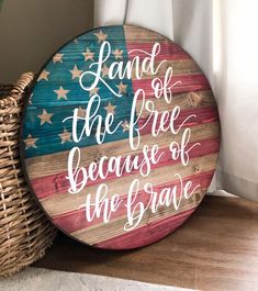 a wooden sign that says land of the free because of the brave on top of a basket