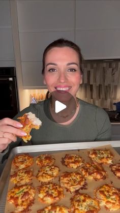 a woman holding up a pizza in front of her face