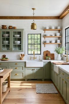 a kitchen filled with lots of green cabinets and white counter tops next to a wooden floor