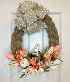 a wreath is hanging on the front door decorated with flowers and polka dot bowknots