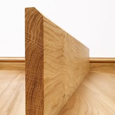 a piece of wood sitting on top of a wooden floor next to a white wall