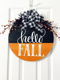 a door hanger with the words hello fall painted in white and black on it