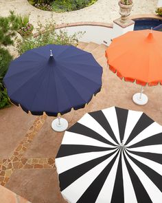 four umbrellas sitting on top of a patio next to each other in different colors