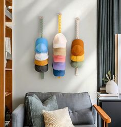 three decorative objects hang on the wall above a gray couch