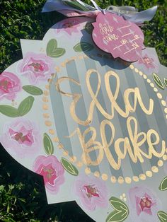 a sign that says ela bake on it in gold lettering and pink flowers