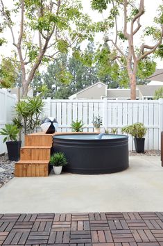 an outdoor hot tub surrounded by potted plants