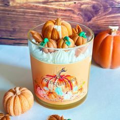 a glass jar filled with frosted pumpkins on top of a table