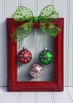 an image of christmas ornaments in a red frame on the wall with green ribbon and bow