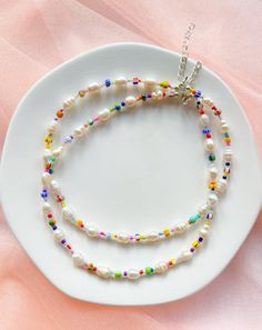 a white plate with two necklaces on it