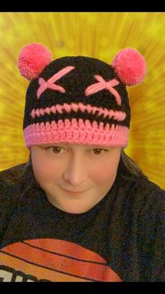 a young boy wearing a black and pink knitted hat