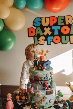 a little boy standing in front of a cake