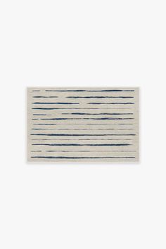 a white and blue striped rug on a white wall with a black stripe in the middle