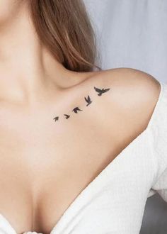 a woman's chest with birds tattoo on her left shoulder and right side breast