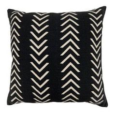 a black and white pillow with an arrow pattern on the front, sitting on a white background