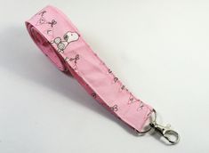 This cute lanyard has beautiful cute peanuts on pink with hugs. It is perfect for any occasion. You can leave me a convoy if you need a different size. You can have a wardrobe of lanyard to match your outfit. This lanyard is made of soft 100% cotton fabric to give a comfortable feel around your neck. This lanyard is easy to take care. You can spot clean and throw in a washer and hang dry. If you want you can iron and it is ready to use. These lanyards are perfect if you have metal allergy. Each of these lanyards will have a slight different pattern depending on where fabric is cut on pattern. This lanyard measures 21 inches long on one side and it is 3/4 inch wide or 42 inches long all over around neck. Multiple orders are welcome and I take custom orders too on all my lanyards. All the pr Pink Lanyard With Key Leash For Gift, Cute Pink Badge Holder As Gift, Cute Pink Badge Holders For Gift, Cute Pink Badge Holders As Gift, Fun Pink Badge Holders For Gift, Fun Pink Badge Holders, Cute Lanyard, Cute Lanyards, Fabric Lanyard