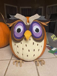 an owl pumpkin sitting on top of a tiled floor